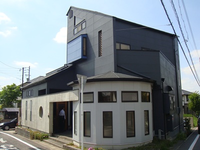 道路沿いに建つ黒と白の住宅兼事務所